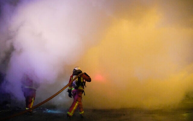 Firefighters extinguish the flame in Nanterre, outside Paris, France, Saturday, July 1, 2023. French President Emmanuel Macron urged parents Friday to keep teenagers at home and proposed restrictions on social media to quell rioting spreading across France over the fatal police shooting of a 17-year-old driver. (AP Photo/Lewis Joly)