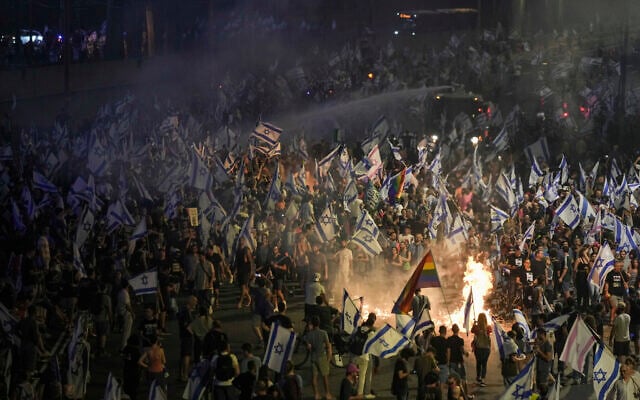 Police use a water cannon to disperse demonstrators blocking the freeway during protest against plans by Prime Minister Benjamin Netanyahu's government to overhaul the judicial system in Tel Aviv, July 5, 2023 (AP Photo/Oded Balilty) Police use a water cannon to disperse demonstrators blocking the freeway during protest against plans by Prime Minister Benjamin Netanyahu's government to overhaul the judicial system in Tel Aviv, July 5, 2023 (AP Photo/Oded Balilty)