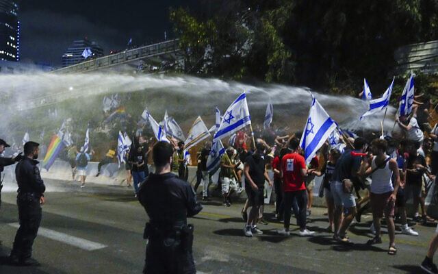 Israeli police use a water cannon to disperse demonstrators blocking a freeway during a protest against plans by Prime Minister Benjamin Netanyahu's government to overhaul the judicial system in Tel Aviv, July 8, 2023. (AP Photo/Ohad Zwigenberg) Israeli police use a water cannon to disperse demonstrators blocking a freeway during a protest against plans by Prime Minister Benjamin Netanyahu's government to overhaul the judicial system in Tel Aviv, July 8, 2023. (AP Photo/Ohad Zwigenberg)