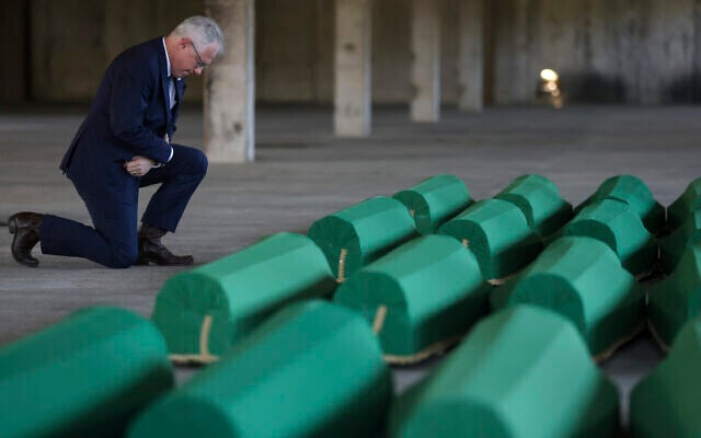 United States Ambassador to Bosnia and Herzegovina Michael J. Murphy kneels next to the coffins containing remains of 30 newly identified victims of the Srebrenica Genocide in Potocari, Bosnia, July 10, 2023. (AP/Armin Durgut) United States Ambassador to Bosnia and Herzegovina Michael J. Murphy kneels next to the coffins containing remains of 30 newly identified victims of the Srebrenica Genocide in Potocari, Bosnia, July 10, 2023. (AP/Armin Durgut)