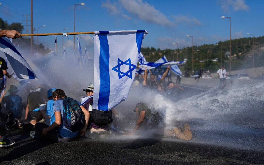 Police use a water cannon to disperse demonstrators blocking a highway leading to Jerusalem, July 11, 2023 (AP Photo/Ohad Zwigenberg)