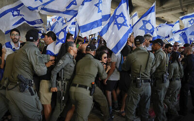 Border police officers scuffle with demonstrators during a protest against plans by Prime Minister Benjamin Netanyahu's government to overhaul the judicial system, at Ben Gurion Airport, July 11, 2023 (AP Photo/Ariel Schalit)