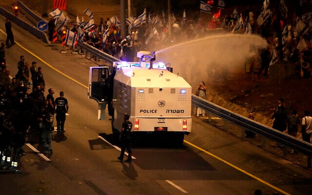 Police use a water cannon to disperse demonstrators protesting against plans by Prime Minister Benjamin Netanyahu's government to overhaul the judicial system, in Tel Aviv, July 18, 2023. (Ariel Schalit/AP)