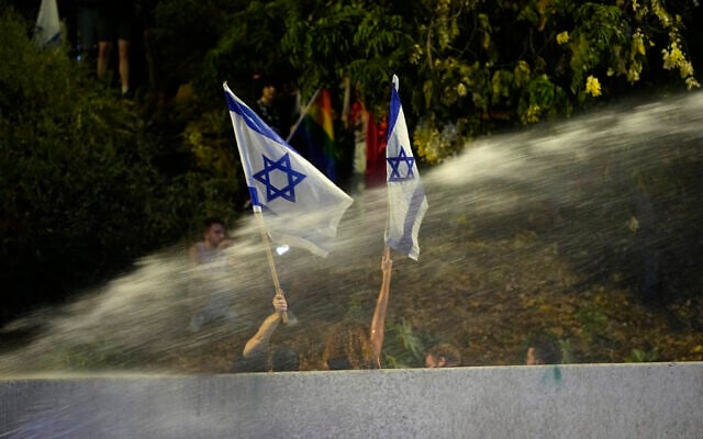 Police use a water cannon on Israelis at the Ayalon Highway protesting against plans by Prime Minister Benjamin Netanyahu's government to overhaul the judicial system, in Tel Aviv, Thursday, July 2), 2023. (AP Photo/Ohad Zwigenberg)