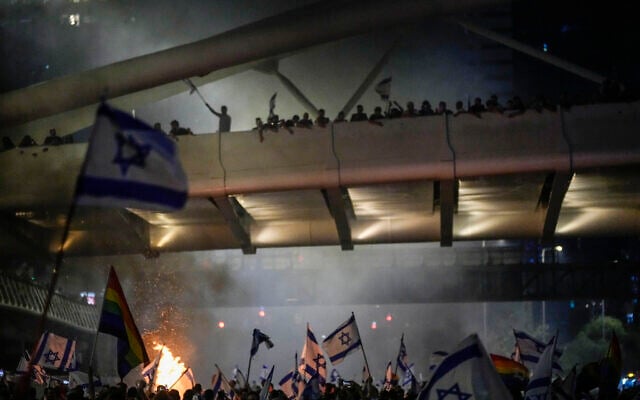 Bonfires burn as Israelis occupy the Ayalon Highway to protest against plans by Prime Minister Benjamin Netanyahu's government to overhaul the judicial system, in Tel Aviv, Thursday, July 20, 2023. (AP Photo/Ariel Schalit)