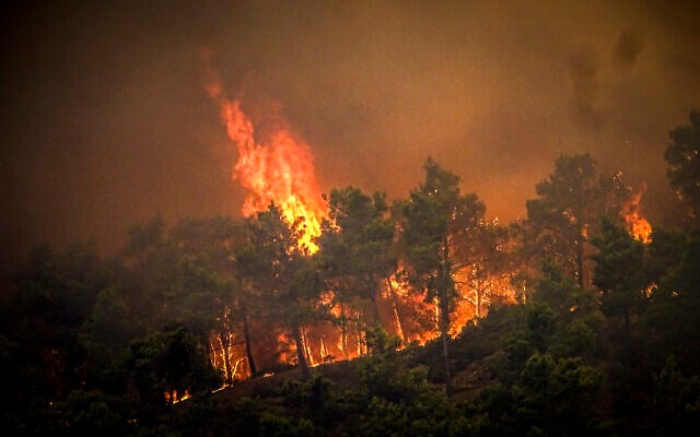 Flames rise during a forest fire on the island of Rhodes, Greece, Saturday, July 22, 2023. (Argyris Mantikos/Eurokinissi via AP) Flames rise during a forest fire on the island of Rhodes, Greece, Saturday, July 22, 2023. (Argyris Mantikos/Eurokinissi via AP)