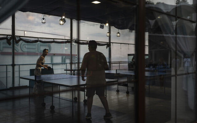Two people play table tennis at a popular beachside attraction along the shore of the Black Sea in Odesa, Ukraine, July 23, 2023. (Jae C. Hong/AP)