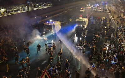 Riot police try to clear demonstrators with a water canon during a protest after Prime Minister Benjamin Netanyahu's government passes the first law to overhaul the judicial system, in Tel Aviv, July 24, 2023. (AP Photo/Oded Balilty)