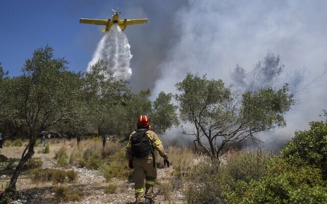 An aircraft drops water over a wildfire in Vati village, on the Aegean Sea island of Rhodes, southeastern Greece, on Tuesday, July 25, 2023. (AP Photo/Petros Giannakouris) An aircraft drops water over a wildfire in Vati village, on the Aegean Sea island of Rhodes, southeastern Greece, on Tuesday, July 25, 2023. (AP Photo/Petros Giannakouris)