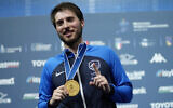 Eli Dershwitz, of the United States, celebrates on the podium after winning the men's Individual Sabre final at the Fencing World Championships in Milan, Italy, July 25, 2023. (Antonio Calanni/AP)