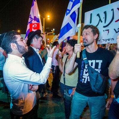 Demonstrators argue with ultra-Orthodox Jews during a protest march in Bnei Brak against funding to ultra-Orthodox parties in the state budget, on May 17, 2023. (Flash90)