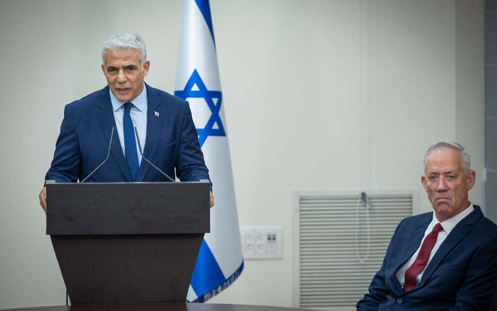 Yesh Atid head Yair Lapid speaks during a press conference next to Benny Gantz, seated, on June 14, 2023. (Yonatan Sindel/Flash90) Yesh Atid head Yair Lapid speaks during a press conference next to Benny Gantz, seated, on June 14, 2023. (Yonatan Sindel/Flash90)
