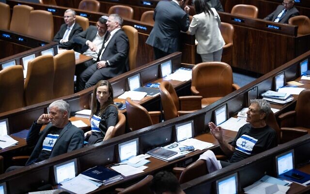 Yesh Atid MKs wear black t-shirts adorned with Israeli flags during plenum deliberations on the 'reasonableness' bill, at the Knesset, July 10, 2023. (Yonatan Sindel/Flash90) Yesh Atid MKs wear black t-shirts adorned with Israeli flags during plenum deliberations on the 'reasonableness' bill, at the Knesset, July 10, 2023. (Yonatan Sindel/Flash90)