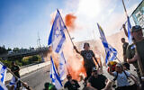 Demonstrators block a road and clash with police during a protest against the judicial overhaul on Route 1, near Ein Hemed, July 11, 2023. (Chaim Goldberg/Flash90)