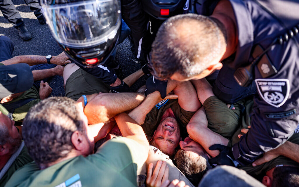 Demonstrators block a road and clash with police during a protest against the judicial overhaul on Route 1, near Ein Hemed, July 11, 2023. (Chaim Goldberg/Flash90)