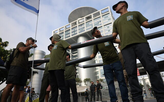 Demonstrators block the entrance to the Defense Ministry in Tel Aviv as they protest the government's judicial overhaul plans, on July 18, 2023. (Chaim Goldberg/Flash90) Demonstrators block the entrance to the Defense Ministry in Tel Aviv as they protest the government's judicial overhaul plans, on July 18, 2023. (Chaim Goldberg/Flash90)