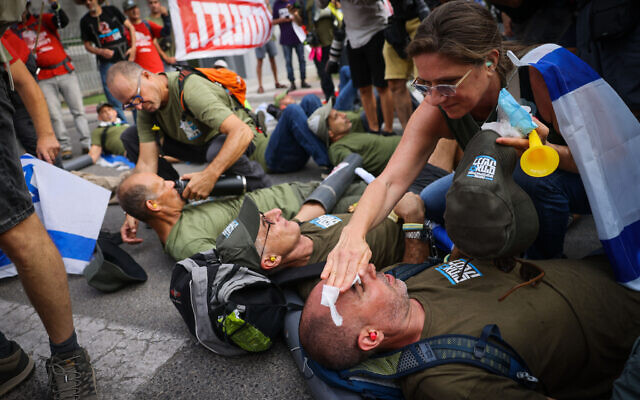 Israelis block the entrance to IDF headquarters in Tel Aviv as they protest the government's judicial overhaul, July 18, 2023. (Chaim Goldberg/Flash90) Israelis block the entrance to IDF headquarters in Tel Aviv as they protest the government's judicial overhaul, July 18, 2023. (Chaim Goldberg/Flash90)