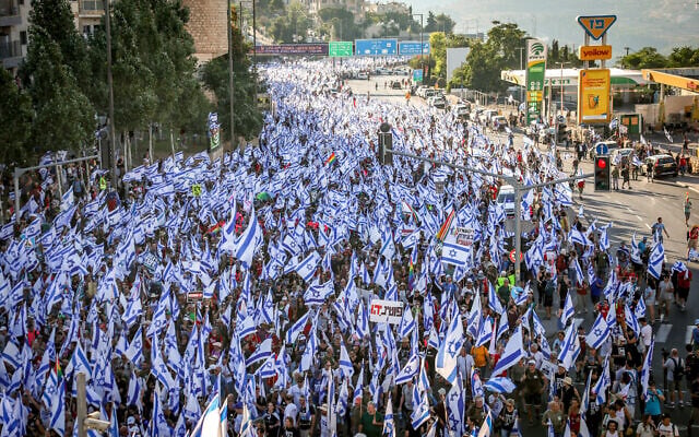 Tens of thousands of demonstrators wave Israeli flags as they march into Jerusalem on July 22, 2023, during a multi-day march that started in Tel Aviv to protest the government's judicial overhaul legislation ahead of a vote on the first such law in the Knesset. (Yonatan Sindel/Flash90) Tens of thousands of demonstrators wave Israeli flags as they march into Jerusalem on July 22, 2023, during a multi-day march that started in Tel Aviv to protest the government's judicial overhaul legislation ahead of a vote on the first such law in the Knesset. (Yonatan Sindel/Flash90)