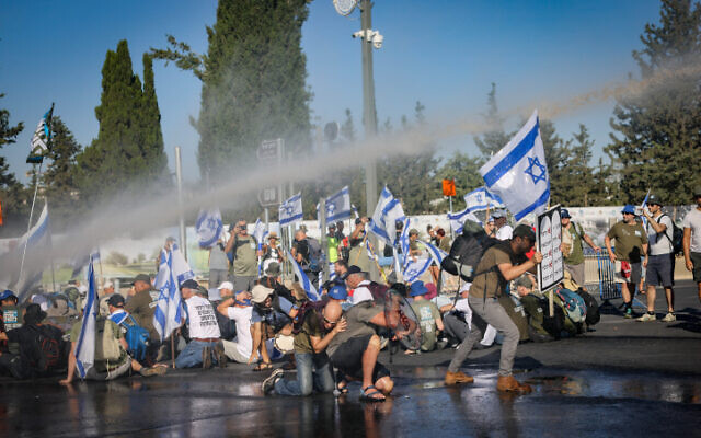 Anti-overhaul activists block a road during a protest against the government's judicial overhaul, near the Knesset in Jerusalem, on July 24, 2023. (Chaim Goldberg/Flash90) Anti-overhaul activists block a road during a protest against the government's judicial overhaul, near the Knesset in Jerusalem, on July 24, 2023. (Chaim Goldberg/Flash90)
