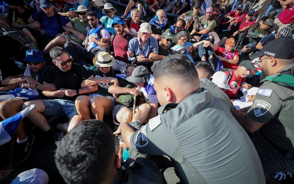 Police grapple with anti-overhaul activists blocking a road near the Knesset on July 24, 2023. (Jamal Awad/Flash90)