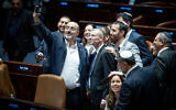 Coalition lawmakers crowd around Justice Minister Yariv Levin to take a celebratory selfie in the Knesset plenum, as they pass the first of the coalition's judicial overhaul laws, the so-called "reasonableness law", on July 24, 2023. (Yonatan Sindel/Flash90)