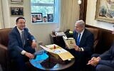 In this handout photo, Prime Minister Benjamin Netanyahu (right) holds a autographed copy of Chinese leader Xi Jinping's book that was given to him by China's Ambassador to Israel Cai Run, at the Prime Minister's Office in Jerusalem, July 26, 2023 (Courtesy)