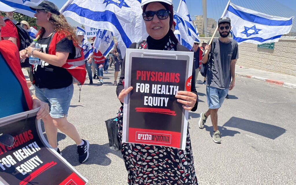 Dr. Ain Hajj Yahia, a family doctor and endocrinologist who works in Jerusalem for the Clalit HMO protests against the government's plan for judicial overhaul. Jerusalem, July 23, 2023. (Renee Ghert-Zand/Times of Israel)