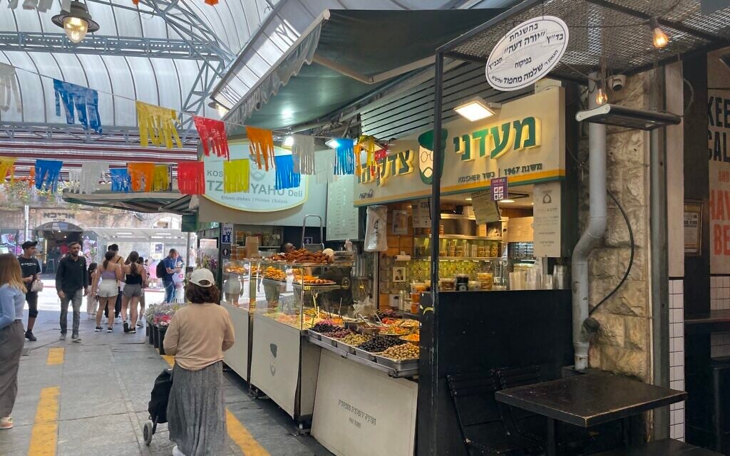 The stall of Tzidkiyahu Deli, a 100-year business in Jerusalem's Mahane Yehuda market, July 2023 (Jessica Steinberg/Times of Israel)