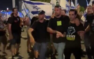 Singer Aviv Geffen (right) is detained by Israel Police at a Tel Aviv protest against the judicial overhaul on July 11, 2023. (Screen capture/Twitter)