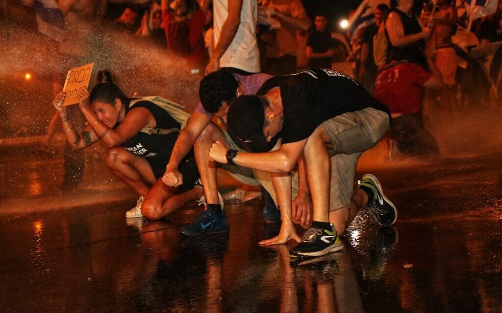 Protesters in Karkur being hit with a police water cannon on July 11, 2023. (Courtesy: Avner Michaeli/National protests against dictatorship in Israel)