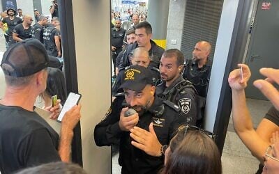 Police officer Meir Suissa orders demonstrators to leave as they are blocked from entering Tel Aviv's Hashalom train station on July 18, 2023. (Carrie Keller-Lynn/Times of Israel)