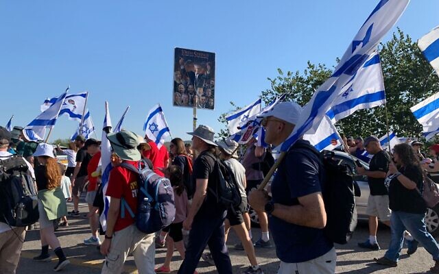 Anti-overhaul protesters march along Highway 424 toward Kibbutz Nahshon on third day of a march to Jerusalem, July 20, 2023. (Charlie Summers/Times of Israel)