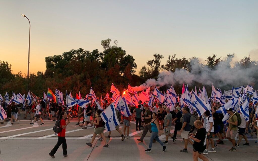 Anti-overhaul demonstrators marching toward Kibbutz Nahshon on Highway 3 on July 20, 2023, blocking half of the road. (Charlie Summers/Times of Israel)