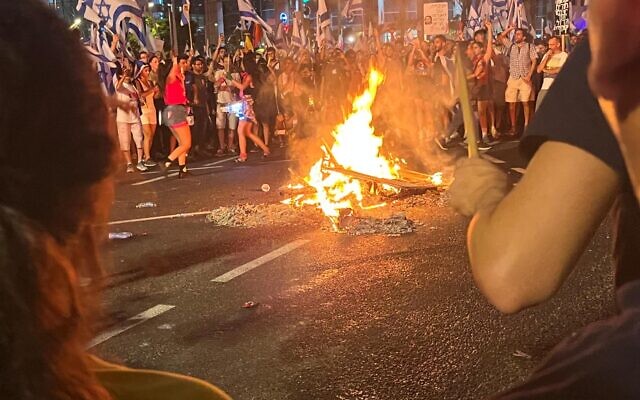 Demonstrators gather at a bonfire during a protest against the government's judicial overhaul, in Tel Aviv on July 24, 2023. (Naomi Lanzkron) Demonstrators gather at a bonfire during a protest against the government's judicial overhaul, in Tel Aviv on July 24, 2023. (Naomi Lanzkron)