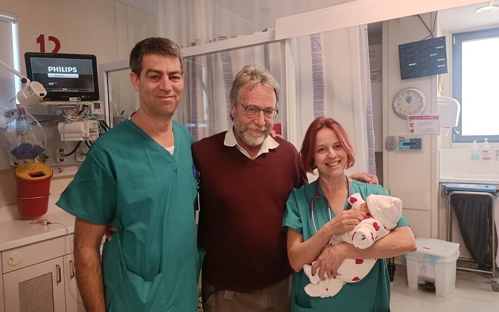 Dr. Noa Ofek Shlomai, head of neonatology at Hadassah Medical Center, holds the baby who successfully underwent surgery immediately following birth to correct bilateral ovarian torsion detected in-utero. Next to them are Dr. Dan Arbel (center), director of the pediatric oncology surgery department, and Dr. Shay Porat, director of the obstetrics and gynecology ultrasound service. (courtesy) Dr. Noa Ofek Shlomai, head of neonatology at Hadassah Medical Center, holds the baby who successfully underwent surgery immediately following birth to correct bilateral ovarian torsion detected in-utero. Next to them are Dr. Dan Arbel (center), director of the pediatric oncology surgery department, and Dr. Shay Porat, director of the obstetrics and gynecology ultrasound service. (courtesy)