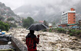 A man looks at a swollen Beas River following heavy rains in Kullu, Himachal Pradesh, India, July 9, 2023. (AP Photo/Aqil Khan, File)