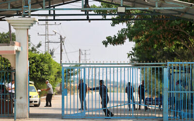 A Palestinian police officer shuts the main gate to Beit Hanun at the Erez crossing between Israel and the northern Gaza Strip, on August 4, 2022. (MOHAMMED ABED / AFP)