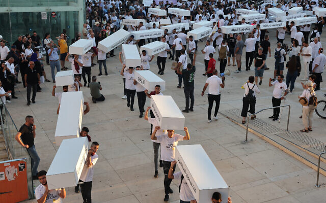 Activists march with symbolic coffins denouncing the violent crimes against Arab communities on August 6, 2023, in Tel Aviv. (JACK GUEZ / AFP) Activists march with symbolic coffins denouncing the violent crimes against Arab communities on August 6, 2023, in Tel Aviv. (JACK GUEZ / AFP)