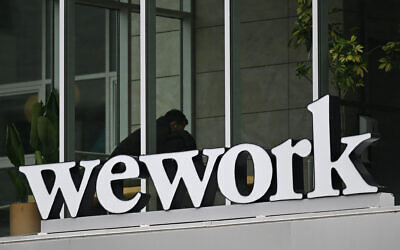 The WeWork logo is displayed outside of an office space rental location in Santa Monica, California on March 20, 2023.(Photo by Patrick T. Fallon / AFP)