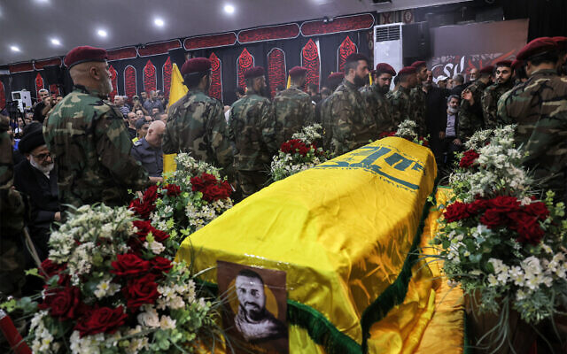 Fighters of the Lebanese Shiite Hezbollah terror group gather around the body of a fallen comrade during his funeral in Beirut's predominantly-Shiite Muslim southern suburb on August 10, 2023 after he was killed the previous day amidst clashes between Hezbollah and residents of the Christian town of Kahale in Mount Lebanon. (Anwar Amro/AFP)