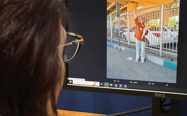 A woman in the Cypriot capital Nicosia looks at a screen displaying an image posted on the X (formerly Twitter) platform's account of Iranian journalist Nazila Maroufian on August 13, 2023, reportedly showing her flashing the victory sign upon her release from Tehran's Evin prison. (Alex Mita/AFP) A woman in the Cypriot capital Nicosia looks at a screen displaying an image posted on the X (formerly Twitter) platform's account of Iranian journalist Nazila Maroufian on August 13, 2023, reportedly showing her flashing the victory sign upon her release from Tehran's Evin prison. (Alex Mita/AFP)