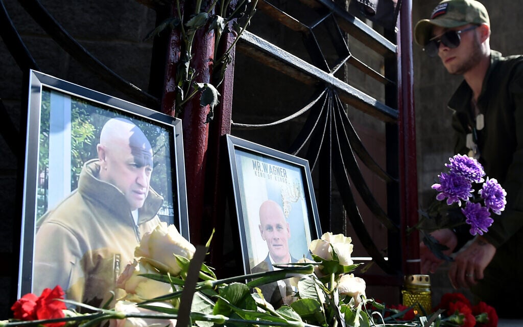 A member of private mercenary group Wagner pays tribute to Yevgeny Prigozhin (L) and Dmitry Utkin, a shadowy figure who managed Wagner's operations and allegedly served in Russian military intelligence, at the makeshift memorial in front of the PMC Wagner office in Novosibirsk, on August 24, 2023. (Photo by Vladimir NIKOLAYEV / AFP) A member of private mercenary group Wagner pays tribute to Yevgeny Prigozhin (L) and Dmitry Utkin, a shadowy figure who managed Wagner's operations and allegedly served in Russian military intelligence, at the makeshift memorial in front of the PMC Wagner office in Novosibirsk, on August 24, 2023. (Photo by Vladimir NIKOLAYEV / AFP)