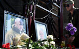 A member of private mercenary group Wagner pays tribute to Yevgeny Prigozhin (L) and Dmitry Utkin, a shadowy figure who managed Wagner's operations and allegedly served in Russian military intelligence, at the makeshift memorial in front of the PMC Wagner office in Novosibirsk, on August 24, 2023. (Photo by Vladimir NIKOLAYEV / AFP)