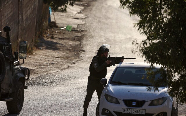A Border Police officer aims a weapon during clashes with Palestinians in the West Bank town of Beita, August 21, 2023. (Jaafar ASHTIYEH / AFP) A Border Police officer aims a weapon during clashes with Palestinians in the West Bank town of Beita, August 21, 2023. (Jaafar ASHTIYEH / AFP)