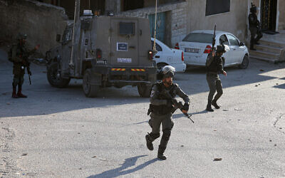 Israeli soldiers and Border Police officers operate in the West Bank town of Beita, August 21, 2023. (Jaafar Ashtiyeh/AFP)