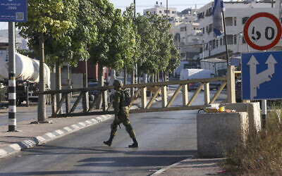An Israeli soldier mans a checkpoint at the closed-off southern entrance to the southern West Bank city of Hebron, on August 22, 2023, a day after a deadly terror shooting in the area. (Hazem Bader/AFP)