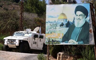 A UNIFIL vehicle patrols near a billboard with a portrait of Hezbollah chief Hassan Nasrallah, in the southern town of Adaisseh, on August 30, 2023. (Mahmoud Zayyat / AFP)