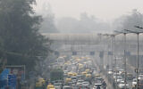 A pedestrian walks on a bridge above vehicle traffic in New Delhi, India, Tuesday, Nov. 12, 2019, as the city is enveloped under thick smog. (AP Photo/Manish Swarup, File)