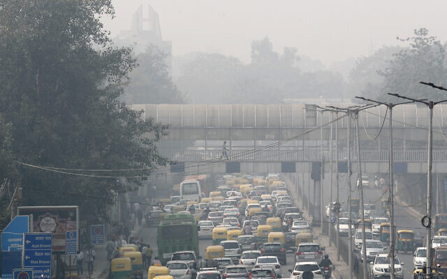 A pedestrian walks on a bridge above vehicle traffic in New Delhi, India, Tuesday, Nov. 12, 2019, as the city is enveloped under thick smog. (AP Photo/Manish Swarup, File)