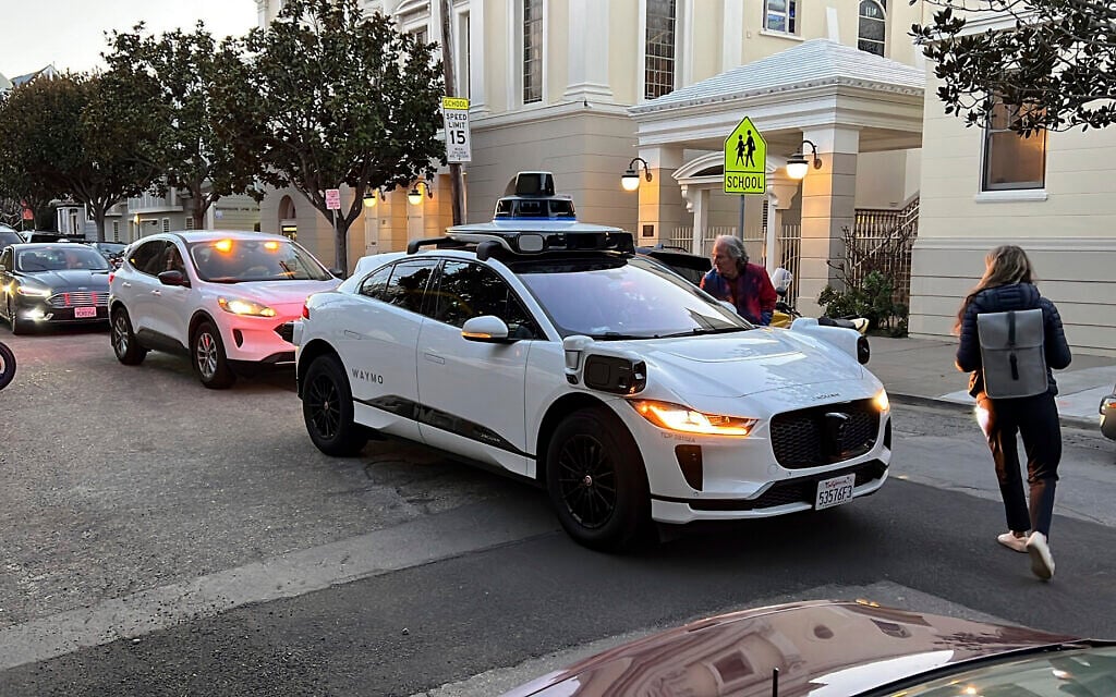Passengers try to figure out why a Waymo driverless taxi won't move while traffic backs up behind it in San Francisco, February 15, 2023. (AP Photo/Terry Chea)